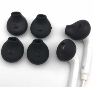 A pair of earbud headphones besides silicone replacements.