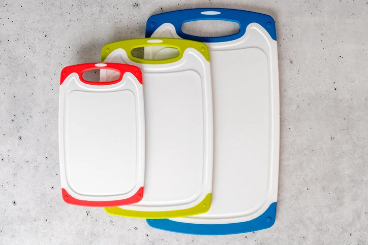 Three cutting boards made of high-density polyethylene lay side-by-side on a countertop.