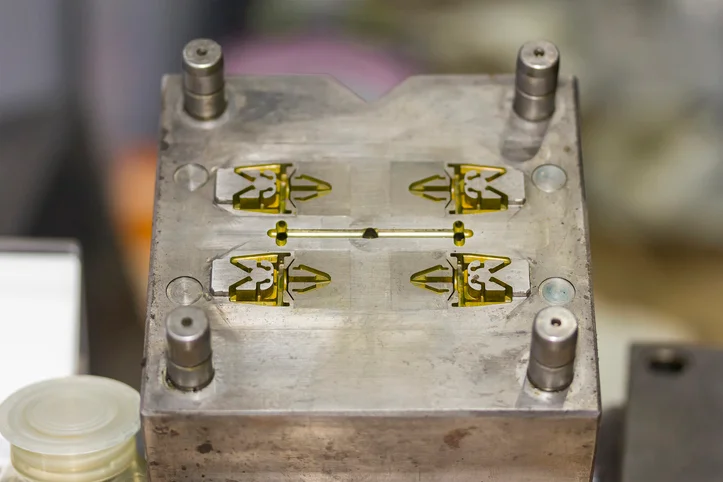 A resin sitting within a plastic injection mold cavity.