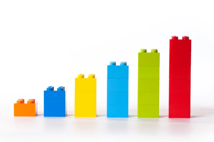 Stacks of colorful legos that mimic a rising bar chart.