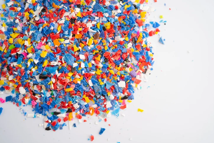 Pieces of colorful regrind materials on a white background.